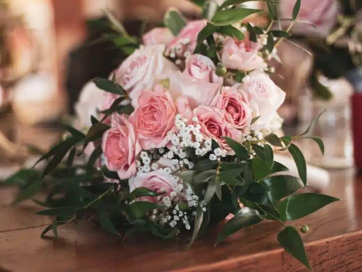 pink roses on brown wooden table